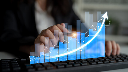 A business professional analyzes digital graphs on a keyboard, symbolizing data trends and growth in a modern office, emphasizing success and analytics. Scalp