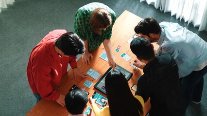 Top view of diverse business people discussing idea and designing system while using tablet with Ux, Ui design display on screen. Multicultural working together and planning strategy. Convocation.