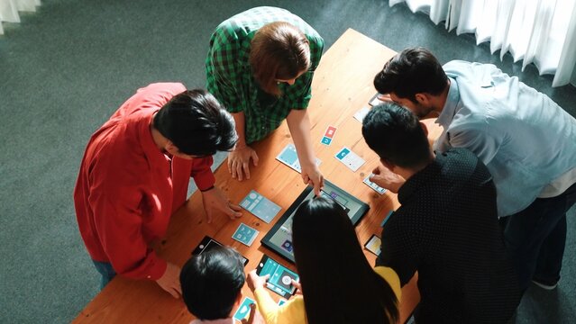 Top view of diverse business people discussing idea and designing system while using tablet with Ux, Ui design display on screen. Multicultural working together and planning strategy. Convocation. - Powered by Adobe