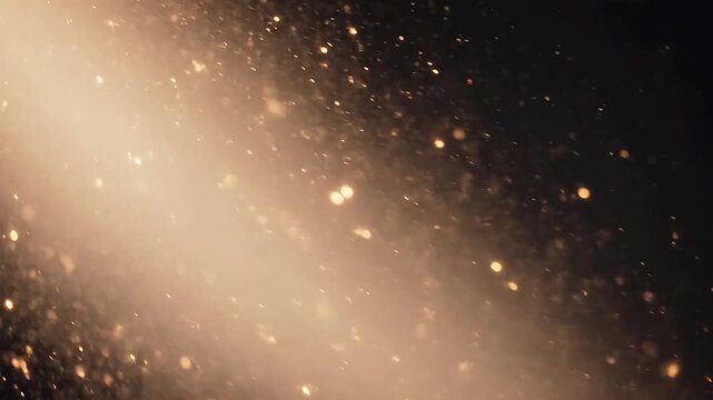 A cinematic dark background featuring a diagonal swath of warm golden light accented by scattering, shimmering bokeh particles, creating a luxurious and celebratory abstract atmosphere