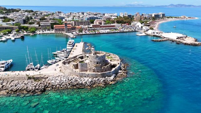 Aerial drone cinematic video of famous Saint Nicholas Fortress built in entrance of Mandraki harbor next to where Colossus of Rhodes was initially built, main town of Rhodes island, Dodecanese, Greece