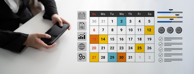 Individual interacts with a smartphone while observing a digital calendar, reflecting modern...