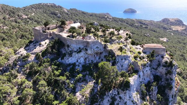 Aerial drone cinematic video of 15th-century Castle of Monolithos built on a cliff with picturesque views of the Aegean sea, Rhodes island, Dodecanese, Greece