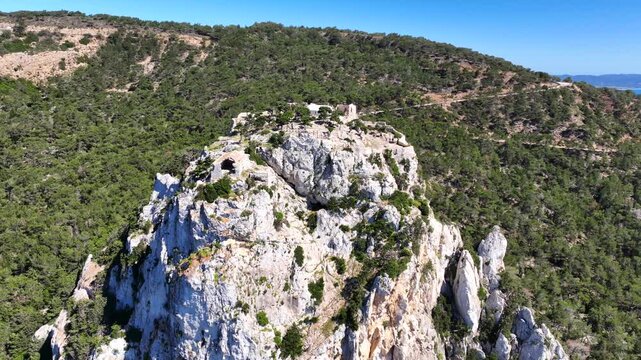 Aerial drone cinematic video of 15th-century Castle of Monolithos built on a cliff with picturesque views of the Aegean sea, Rhodes island, Dodecanese, Greece