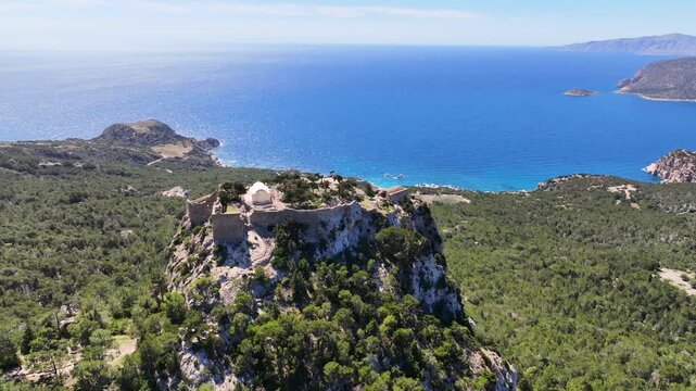 Aerial drone cinematic video of 15th-century Castle of Monolithos built on a cliff with picturesque views of the Aegean sea, Rhodes island, Dodecanese, Greece