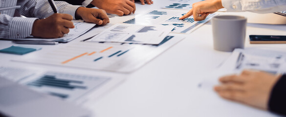 Team members engaged in a collaborative meeting focusing on data trends, utilizing charts and reports to strategize and plan actions for future business growth. SACTR