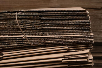 A large pile of corrugated cardboard sheets and flat boxes stacked in warehouse, highlighting packing material, industrial printing storage. Packaging, shipping, and eco-friendly logistics