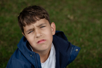 A young boy is upset, disappointed, he didn't get what he wanted, and he's hungry and tired, with puzzled, furrowed brow