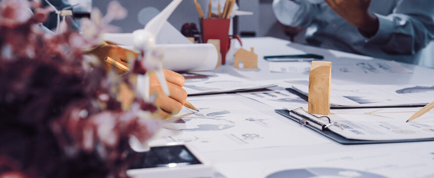Engaging teamwork in a modern workspace focused on sustainability and innovative design solutions. Professionals discuss eco-friendly strategies amidst creative materials. SACTR