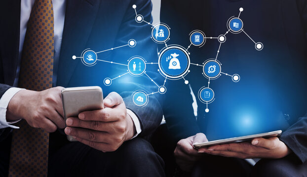 Two business professionals engage with mobile devices while exploring data visualization concepts, highlighting the importance of technology in modern business environments. Tessel - Powered by Adobe