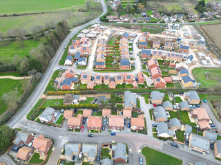 Interesting drone UAV inspection view of newly built homes seen on a sprawling housing development in Britain. Part finished homes can also be seen. Homeowners have moved in.