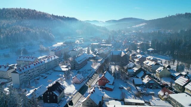 Aerial view of Delnice, Croatia, blanketed in pristine winter snow. Sunlit roofs and frosted forests create a picturesque scene in Gorski Kotar.