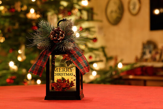 Laterne mit Zapfen und Schleife vor nostalgischem Weihnachtsbaum