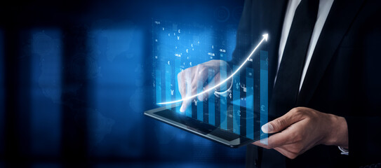 A businessman dressed in a formal suit is analyzing financial data displayed on a tablet. A graph shows a positive trend, symbolizing growth and success in a modern office setting. Impute