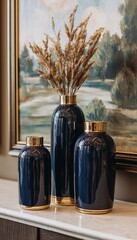 Elegant navy blue vases with golden details and dried plants against artwork background