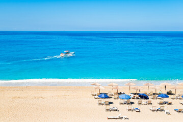 Motor boat on blue sea sailing off Milos beach, Lefkada island, Greece