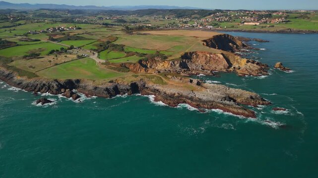Aerial drone gliding left over ocean with distant coastal land view, northern Spain