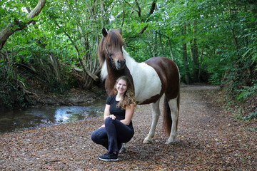 Attraktive junge Frau mit Ihrem Pferd an einem kleinen Bach/Gewässer im Wald © Bittner KAUFBILD.de
