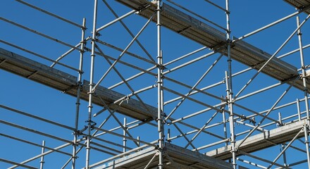 A complex network of metal scaffolding with wooden planks, used in construction.Concept of construction safety and temporary structures.