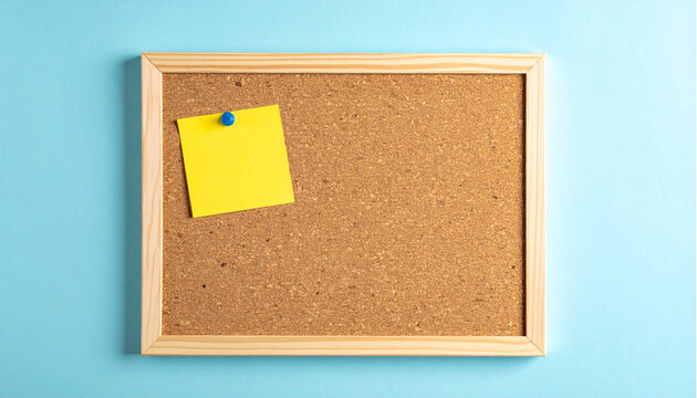 Cork bulletin board with yellow sticky note and blue push pin on pastel blue background. Wooden framed corkboard with a yellow sticky note pinned by a blue tack. For mockups, reminders, presentations.