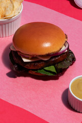 Classic Beef and Cheese Burger presented on a playful Pink Backdrop