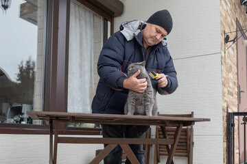 Senior male brushing pet outdoors near house highlighting daily routine compassion and calm interaction with animal.