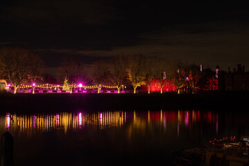 Hampton Court Palace ice rink colourfully lit at night in winter