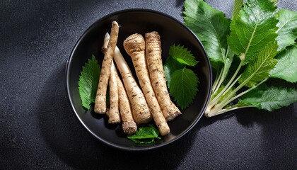 fresh horseradish root and green leaves in black bowl surrounded by greenery evoke sense of natural freshness and culinary delight