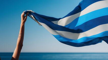 女性がブランドカラー二色のストライプスカーフを海辺で掲げ企業向け表現