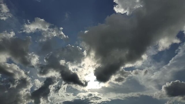 Endless Clouds in the Daytime Sky. A view of clouds and bright sun. Timelapse of the sky and clouds. The sun shines through the clouds against a dramatic sky backdrop.

