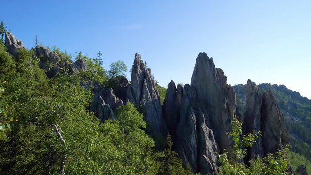 view of the unique Feathers (Perya) rock formations on the slope of Dvuglavaya Sopka in Taganay National Park, near the city of Zlatoust, Chelyabinsk region, Russia. This footage captures the rugged b
