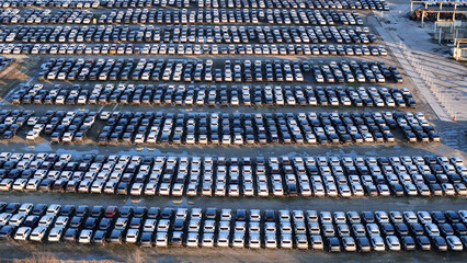Huge lot full of brand new cars displaying mass production and the extensive logistics required for...