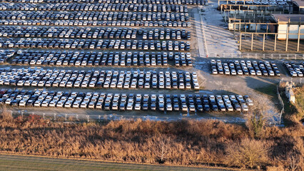 Huge lot full of brand new cars displaying mass production and the extensive logistics required for...