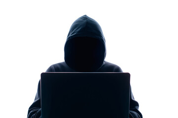 A mysterious figure in a hoodie works on a laptop in a dark room, evoking a sense of cybercrime and cybersecurity threats.
