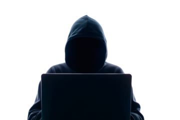 A mysterious figure in a hoodie works on a laptop in a dark room, evoking a sense of cybercrime and cybersecurity threats.
