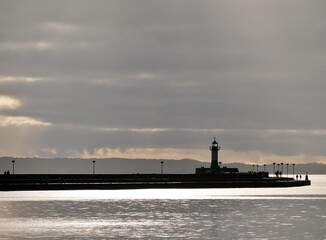 Fototapeta premium Leuchtturm im Hafen von Sassnitz auf Rügen mit Wetterwolken