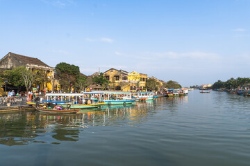 Waterfront with boats and yellow buildings in Hoi An, Vietnam