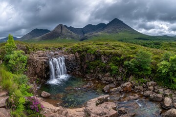 Obraz premium Scenic waterfall cascading into a pool against mountain range landscape