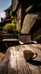 Rustic Wood Table with Speckled Coffee Cup in Sunny Garden Setting Featuring Weathered Wooden Furniture and Natural Rock Formations under Bright Daylight