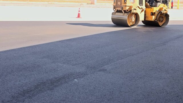 October 14 2025 New York USA Heavy roller asphalt compactor compacts new asphalt on city street under smooth surface.