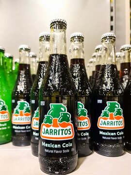 Kiel, Germany - 29. December 2025: Jarritos Mexican Cola soda bottles lining retail shelf