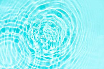 Blue water with ripples on the surface. Defocus blurred transparent blue colored clear calm water surface texture with splashes and bubbles. Water waves with shining pattern texture background.