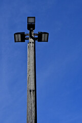 High tech LED parking lot lights retrofitted to old light pole replacing single fluorescent lamp
