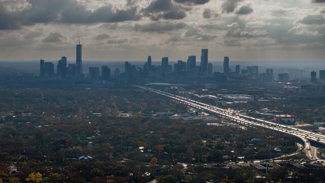 Smooth Aerial Time-Lapse of Austin Skyline with Dramatic Winter Clouds, I-35 Highway Traffic, and Searchlight-like Sun Rays