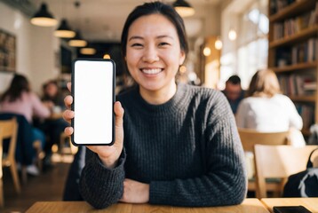 Happy Asian woman presents blank screen smartphone in cafe