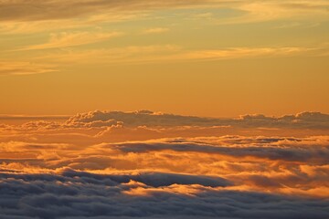 The sun sets above the clouds at the summit of the Haleakala volcano on Maui