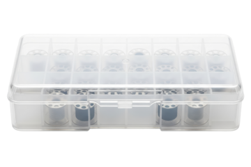 Clear plastic storage box filled with metal sewing machine bobbins on a transparent background