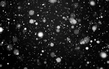 soft falling white snow and glowing bokeh specks against a deep black background, evoking quiet wonder and calm