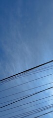 A blue sky filled with wispy cirrus clouds and a single wire cutting through the bottom corner