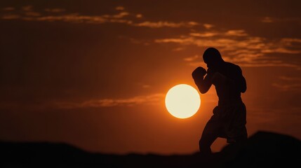 Silhouette of a Boxer in a Fighting Stance Against a Fiery Sunset with Dramatic Clouds.